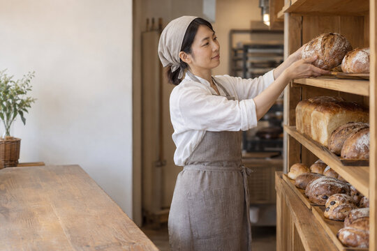 Bakery Worker Arranging Bread for Retail Display