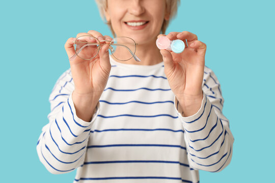 Vision correction choice, senior woman comparing eyeglasses and contact lenses for eye health and ophthalmology care on a solid blue background