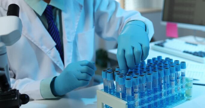 Scientific research and laboratory analysis concept featuring a researcher examining samples, performing experiments and studying test results with modern laboratory equipment.