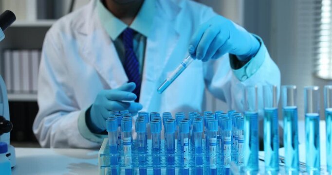 Scientific research and laboratory analysis concept featuring a researcher examining samples, performing experiments and studying test results with modern laboratory equipment.