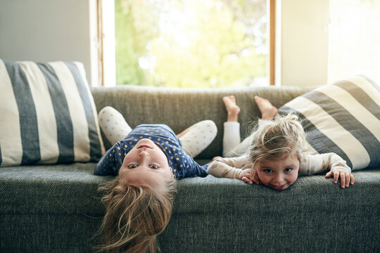 Portrait, sisters and children on sofa, lounge or siblings with smile on break, bonding or together. Happy, girls and relax on couch, home and kids in living room, chill and family in apartment