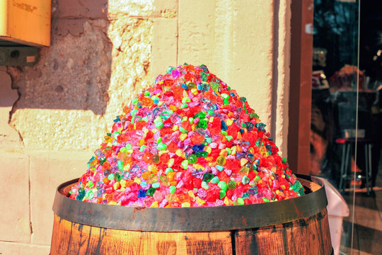 Artificial candies shaped like small stones in wooden barrel near sweets candy shop
