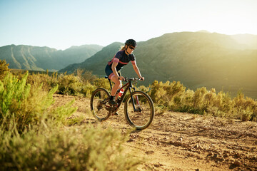Fototapeta premium Woman, cycling and fitness with mountain bike for workout, cardio exercise or extreme outdoor sport. Active, female person or cyclist riding with bicycle on dirt road for training or health in nature