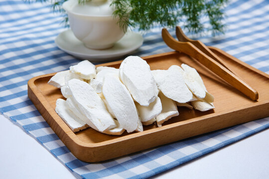 Dried Chinese Yam Slices On Wooden Plate With White Tea Set