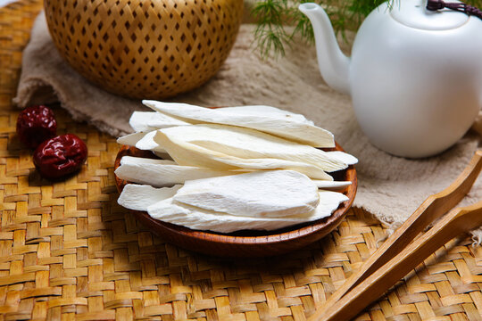 Dried Chinese Yam Slices On Wooden Plate With White Tea Set