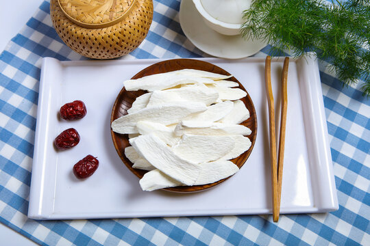 Dried Chinese Yam Slices On Wooden Plate With White Tea Set