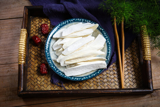 Dried Chinese Yam Slices On Wooden Plate With White Tea Set