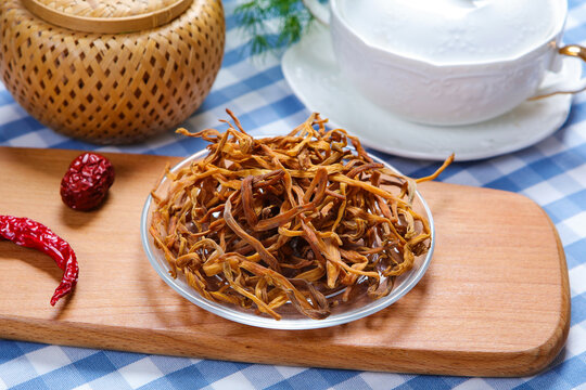 Dried Daylily Flowers On Glass Plate Over Wooden Cutting Board