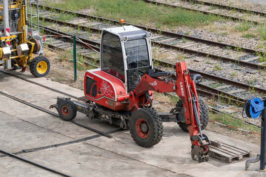 Nancy, France - August 5th 2026 : View on a red mobile walking excavator Euromach R45 on a construction site for railway works with railway lines in the background.