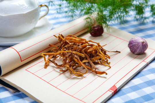 Dried Daylily Flowers On Glass Plate Over Wooden Cutting Board