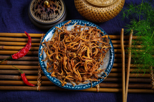 Dried Daylily Flowers On Glass Plate Over Wooden Cutting Board