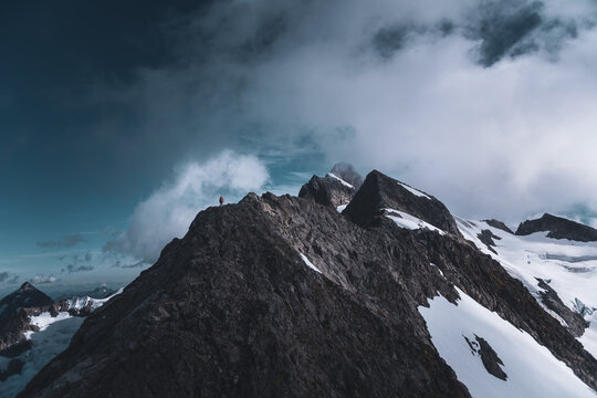 Mountaineer Standing on Summit Ridge Overlooking Tantalus Range