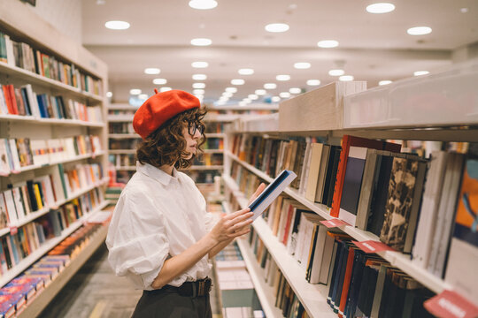 Stylish young woman shops for books in a modern bookstore
