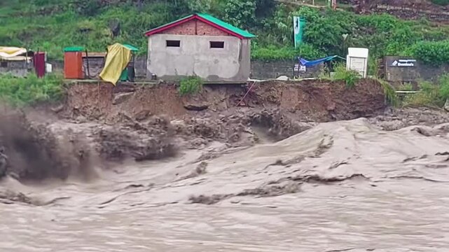 A river overflowing with violent currents as a result of heavy flooding in India.

