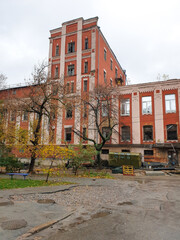 Kyiv, Ukraine reveals a dilapidated red brick industrial complex, an old distillery on Kudriavska Street, featuring a prominent tower, pale contrasting trim, broken windows, and sparse autumn trees © Sodel Vladyslav