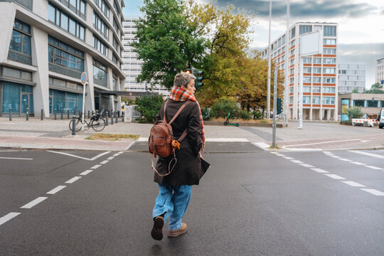 Person walking on city street near buildings in an urban area 