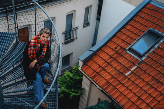 Person seated on spiral staircase in urban setting in the afternoon
