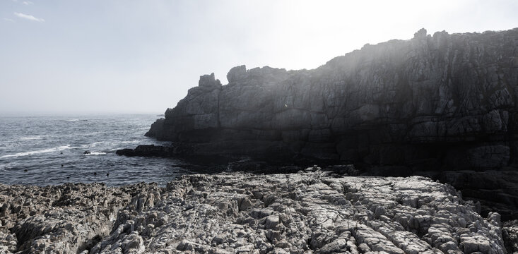 fog bank and afternoon sunlight over rocky coastline of Hermanus, South Africa