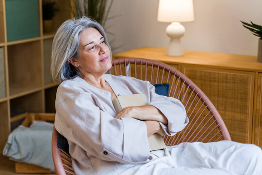 White woman reading a book seated