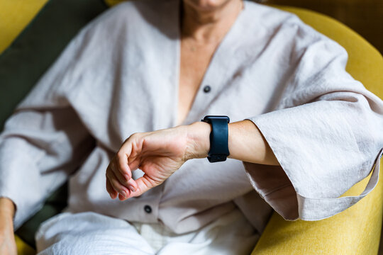 White person wearing a smartwatch on wrist indoors