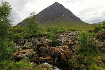 Landscape photo featuring a view of Buachaille Etive Mor mountain and a small waterfall in the foreground, in Glen Coe in the Scottish Highlands, Scotland, United Kingdom © Kateryna M