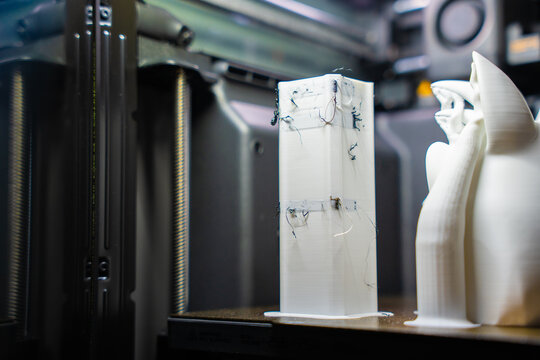 Plastic waste and purge tower from multi-color 3D printing process resting inside a printer chamber.