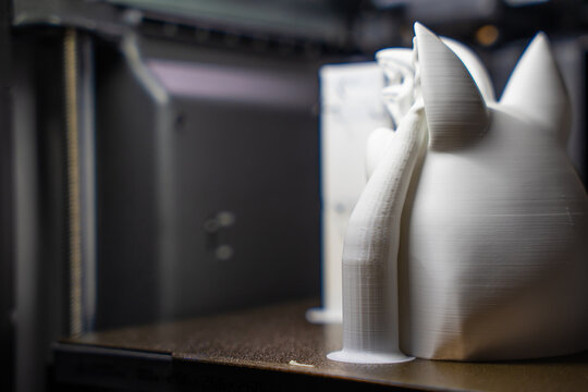 Extreme close-up of 3D printed plastic model showing detailed layer lines and tree support structure.