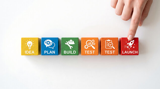 Hand pressing colorful blocks representing product development stages from idea to launch