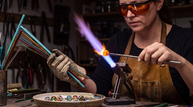 Artisan Shaping Molten Glass Bead on Mandrel in Torch Flame