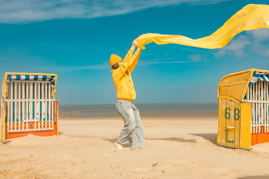 Girl holding yellow plastic during beach cleanup at the North Sea