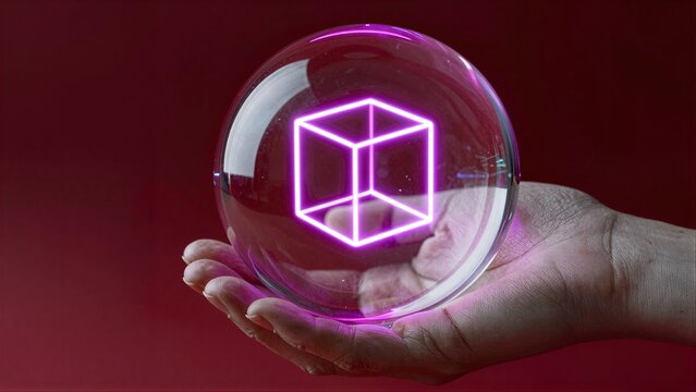 Hand holds glowing purple cube inside transparent sphere against red background.