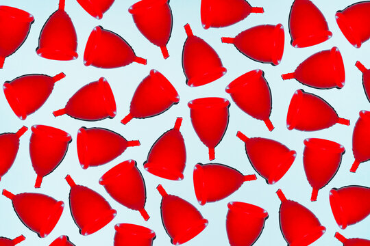 Red menstrual cups form a pattern for feminine hygiene