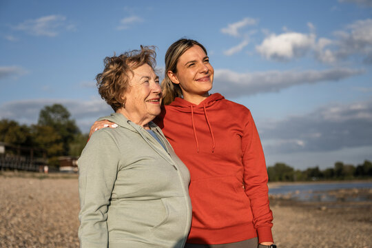 Young woman and senior mother are hugging outdoors in nature