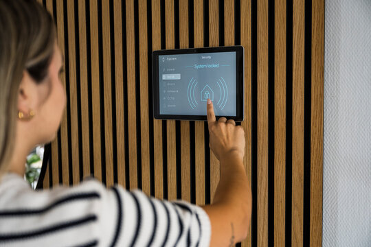 Woman activates security alarm on smarthome tablet at home