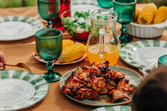 Close-up of grilled chicken on a set outdoor dining table
