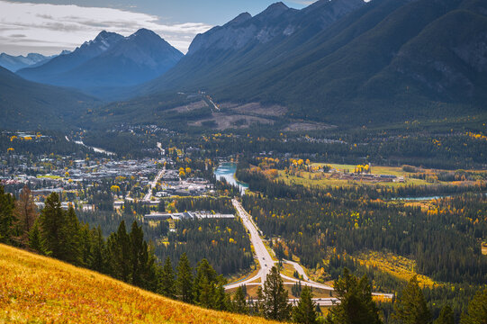 Serene mountain valley town landscape in canada surrounded by forest highway and majestic peak offering peaceful autumn travel view