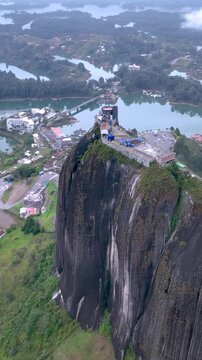 Guatap&eacute; and Iconic Piedra del Pe&ntilde;ol Surrounded by Reservoir Islands and Mountains in Colombia. Establishing Shot. Aerial View. Vertical Video.