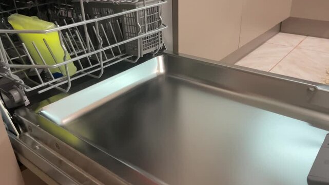 Special liquid cleaner bottle placed upside down inside dishwasher rack for descaling and degreasing cycle to extend appliance service life at home. High quality 4k footage