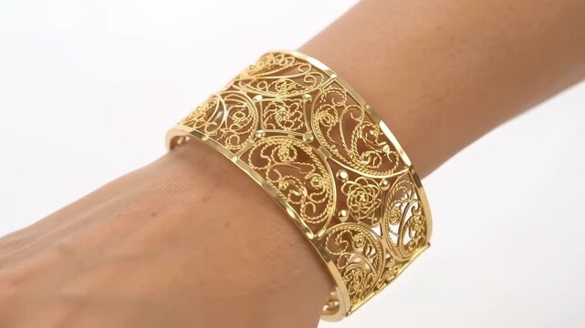 Woman wrist wearing ornate gold filigree cuff bracelet