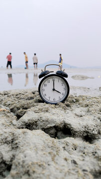 Alarm Clock at Four O'Clock on Beach Rock with Children Playing