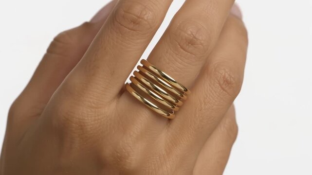 Woman hand wearing modern multi band gold ring on finger