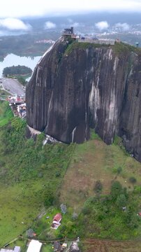 Guatap&eacute; with Piedra del Pe&ntilde;ol Rising Above the Reservoir in Antioquia, Colombia. Establishing Shot. Aerial View. Vertical Video.