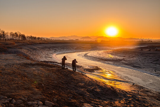Sunrise Landscape at Misenggyo Bridge, Also Known as Bicycle Bridge, in Siheung Tidal Flat Ecological Park, South Korea, with Photographers and Silhouettes
