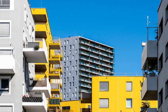 Contemporary apartment buildings in Vienna Austria with yellow facades balconies and a residential tower forming a residential composition of apartment buildings
