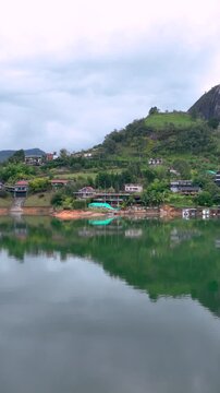 Guatap&eacute; with Piedra del Pe&ntilde;ol Rising Above the Reservoir in Antioquia, Colombia. Establishing Shot. Aerial View. Vertical Video.