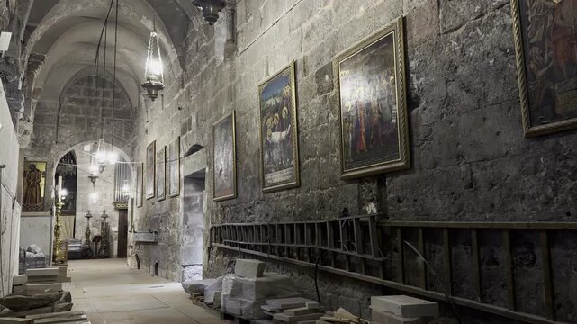 Jerusalem, Israel, October 5, 2026. Passage inside the Church of the Holy Sepulchre leading toward the Edicule, with religious icons and antique hanging lamps along the walls.