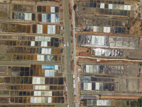 Aerial view of Salt Ponds in Kedung, showcasing geometric evaporation pans and industrial salt production infrastructure in Kedung, Central Java, Indonesia.