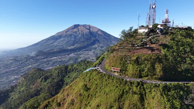 Aerial footage of motorcycle riders descending Mount Telomoyo in Central Java, Indonesia, with scenic Mount Andong and clear mountain landscapes.