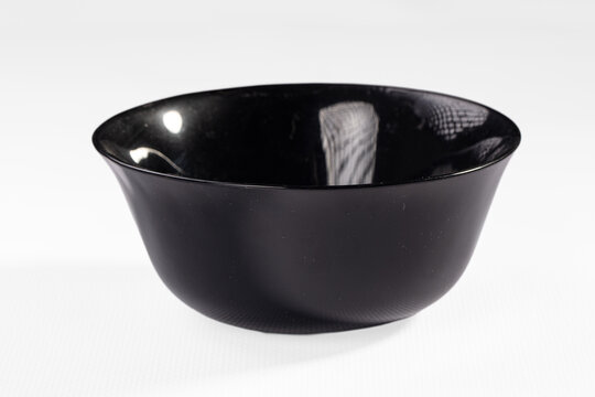 Glossy black ceramic bowl with reflective interior surface isolated on white background for product display