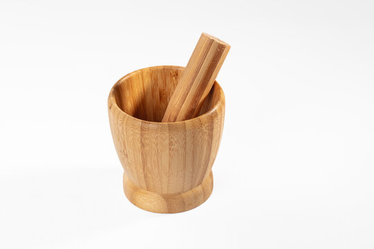 Bamboo mortar and pestle standing on white background with warm wood grain texture, empty kitchen tool for grinding spices and herbs